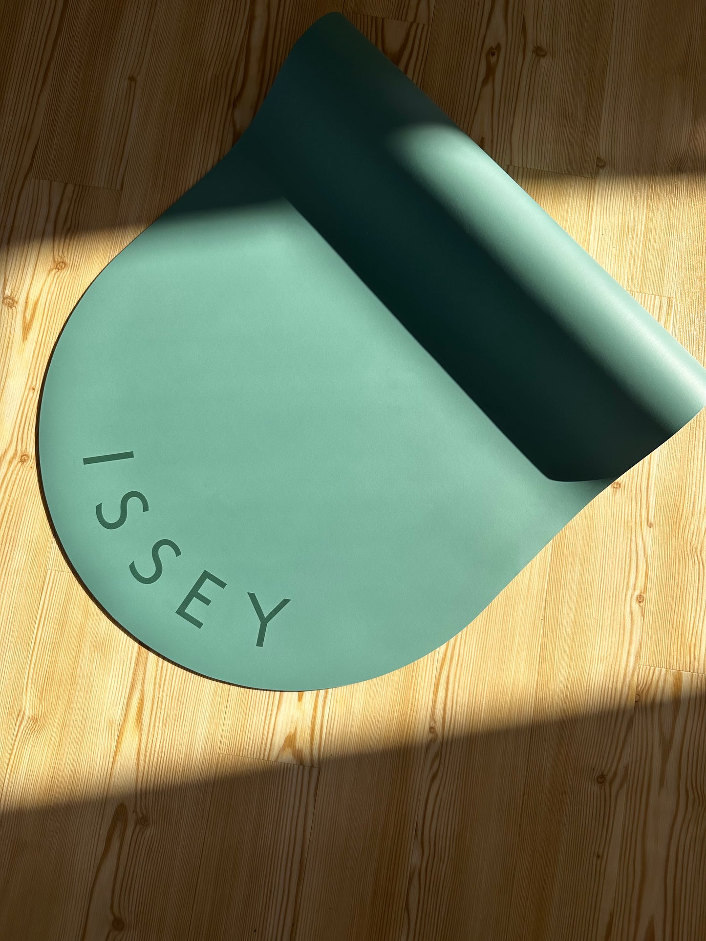 a blue eco yoga mat with the brand name 'ISSEY' printed on it.