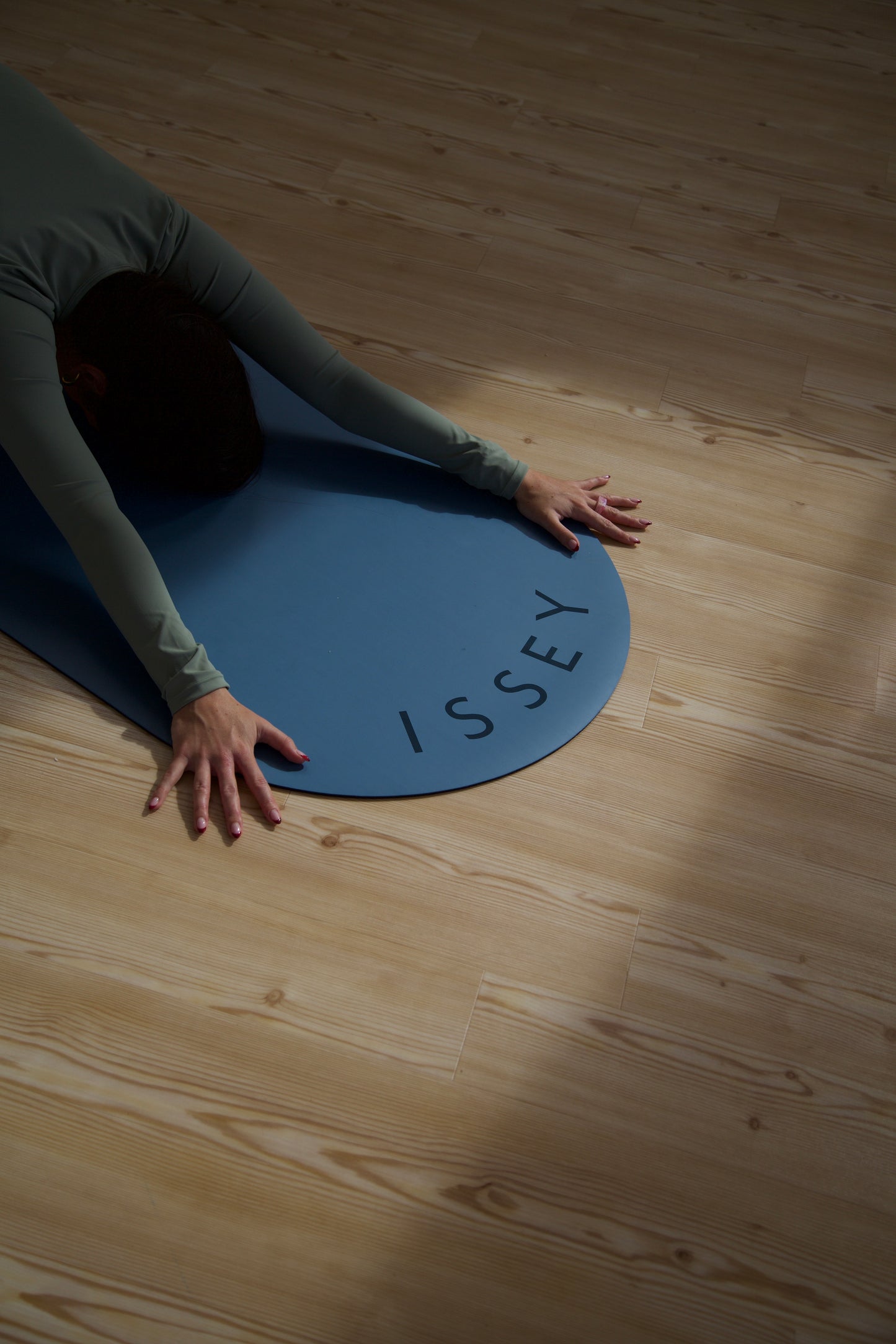 A person in childs pose on a blue aesthetic pilates and yoga eco friendly mat