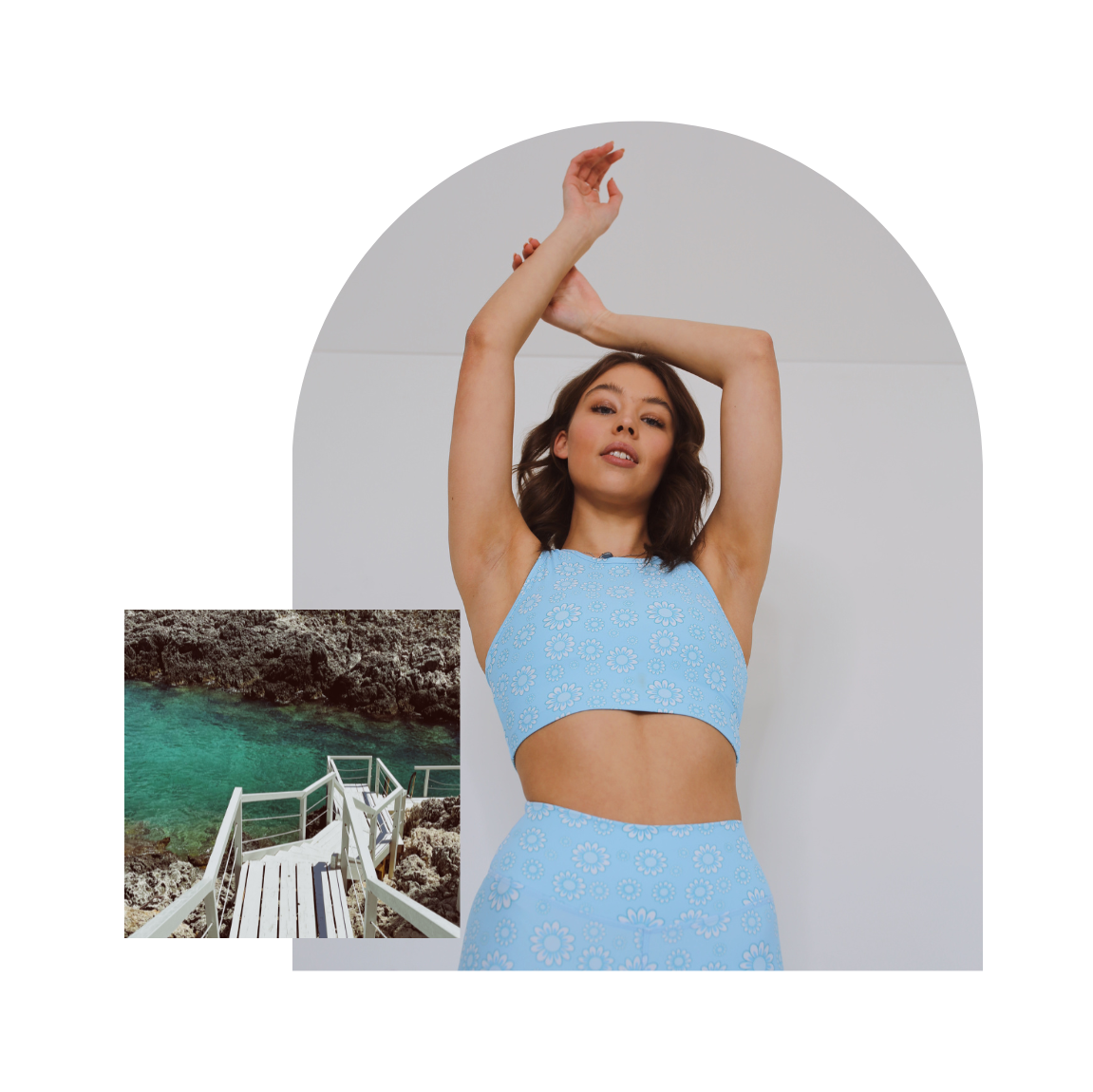 Woman in a light blue outfit standing in front of an archway with a scenic background.