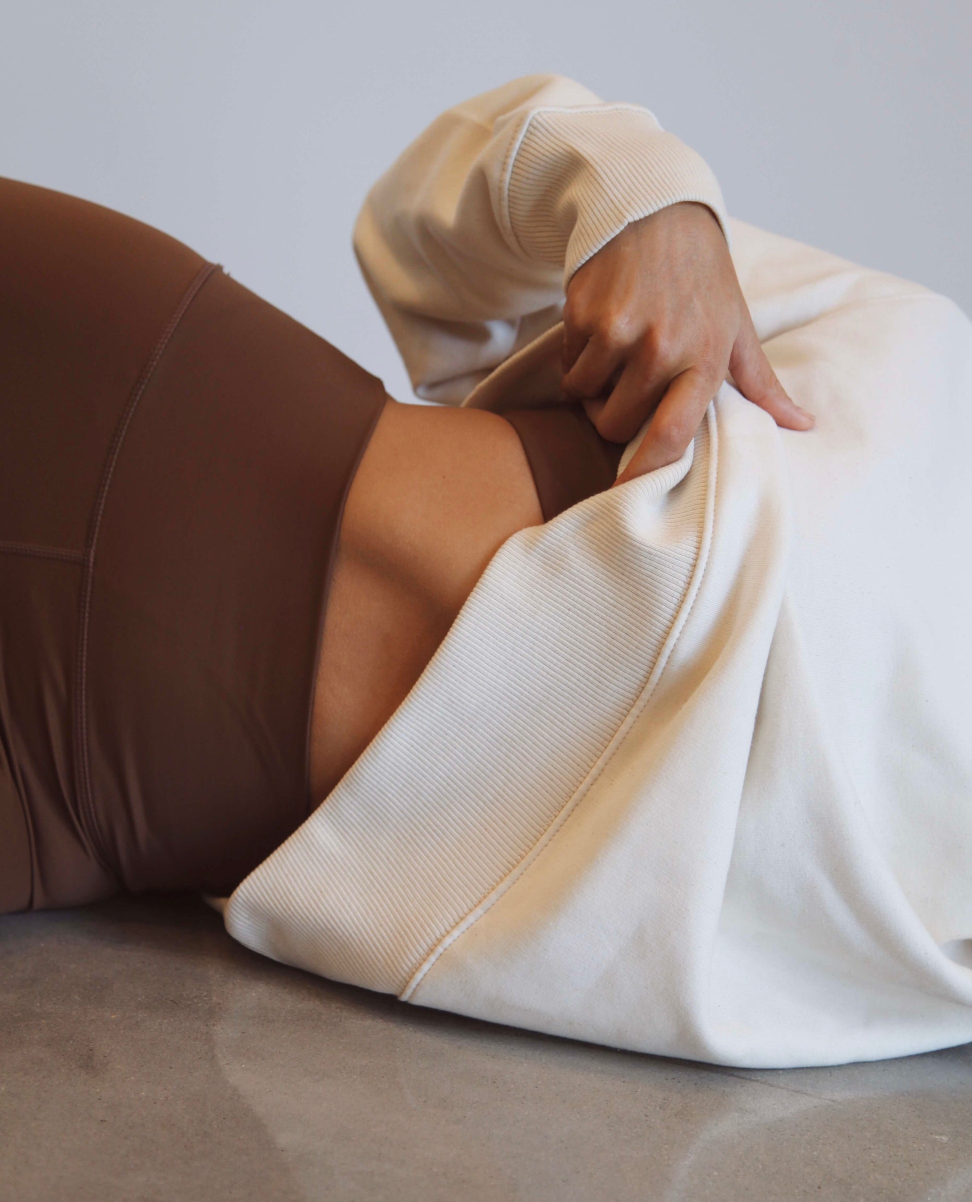 brown yoga set paired with oversized cream jumper